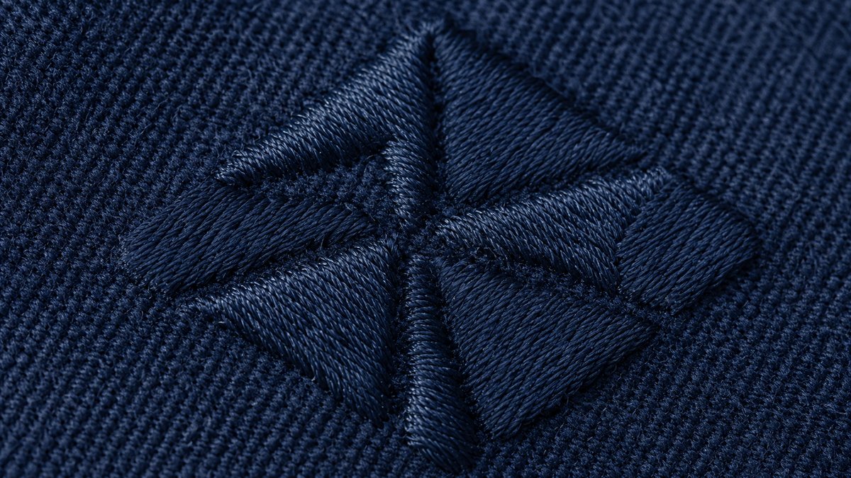 紺色の生地に直接刺繍された図案の拡大。糸の立体感と光沢が見える